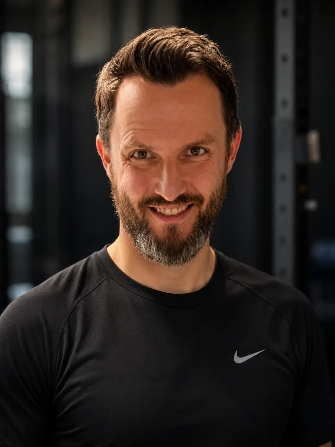 Piotr, trener NCKF Kraków, w czarnej koszulce sportowej na tle sali treningowej